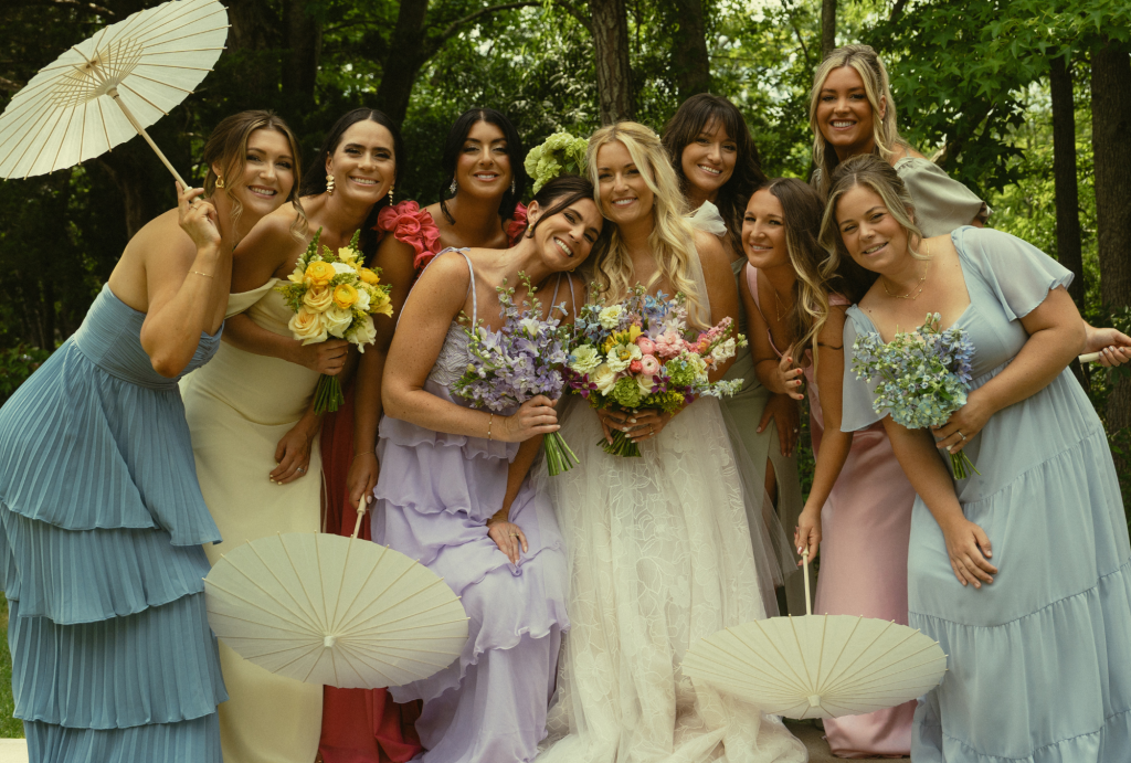 Bride and bridesmaids posing with parasols at coastal Delaware garden party wedding in Ocean View