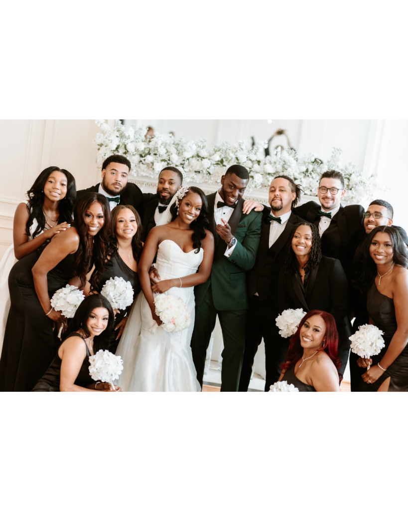 Zee and Bobby posing with their wedding party smiling and celebrating together
