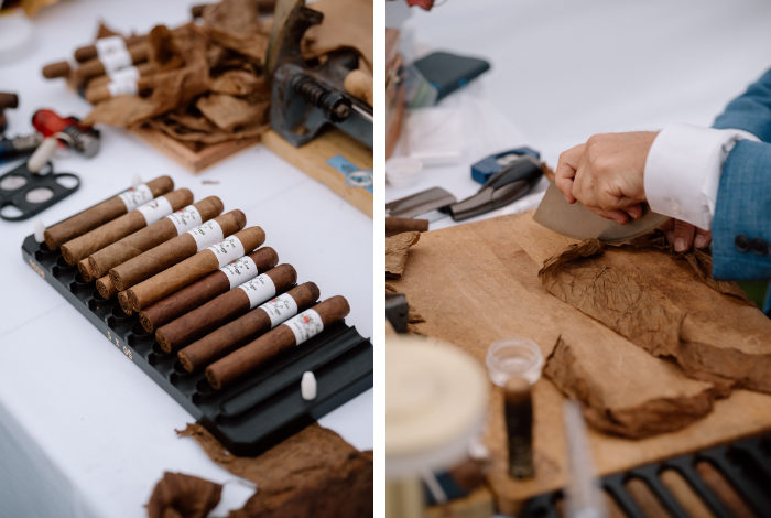 Selection of hand-rolled cigars and tobacco leaves alongside live cigar rolling in progress by Blue Hen Torcedor at a wedding.