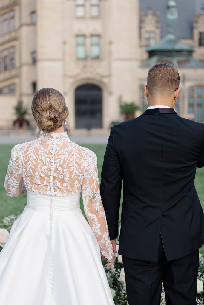 bride and groom facing away from the camera, holding hands