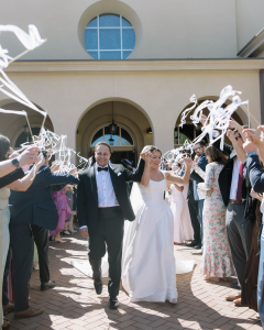 Bride and Groom exiting ceremony with guests on each side celebrating