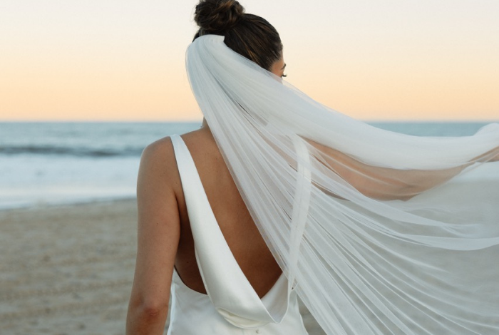 a bride with flowing veil by the ocean in Bethany Beach, Delaware