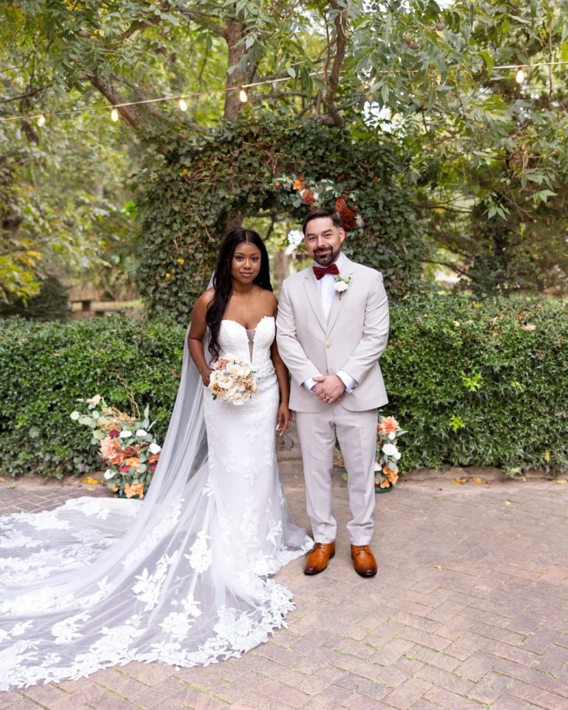 bride and groom portrait infront of green ceremony arch way