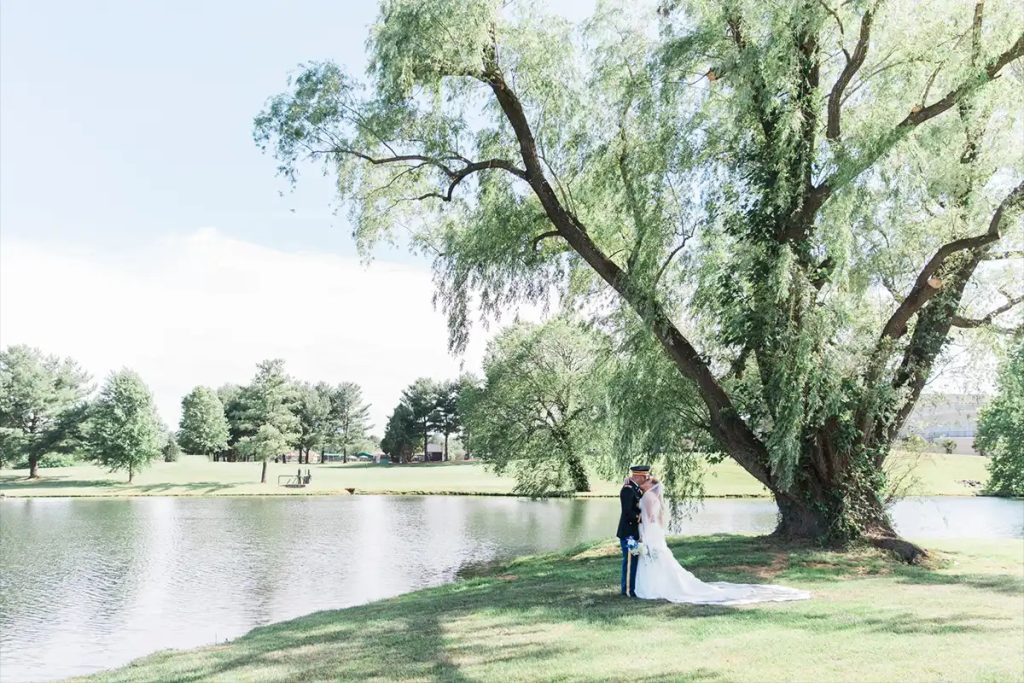Bride and Groom kissing under large tree