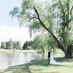 Bride and Groom kissing under large tree