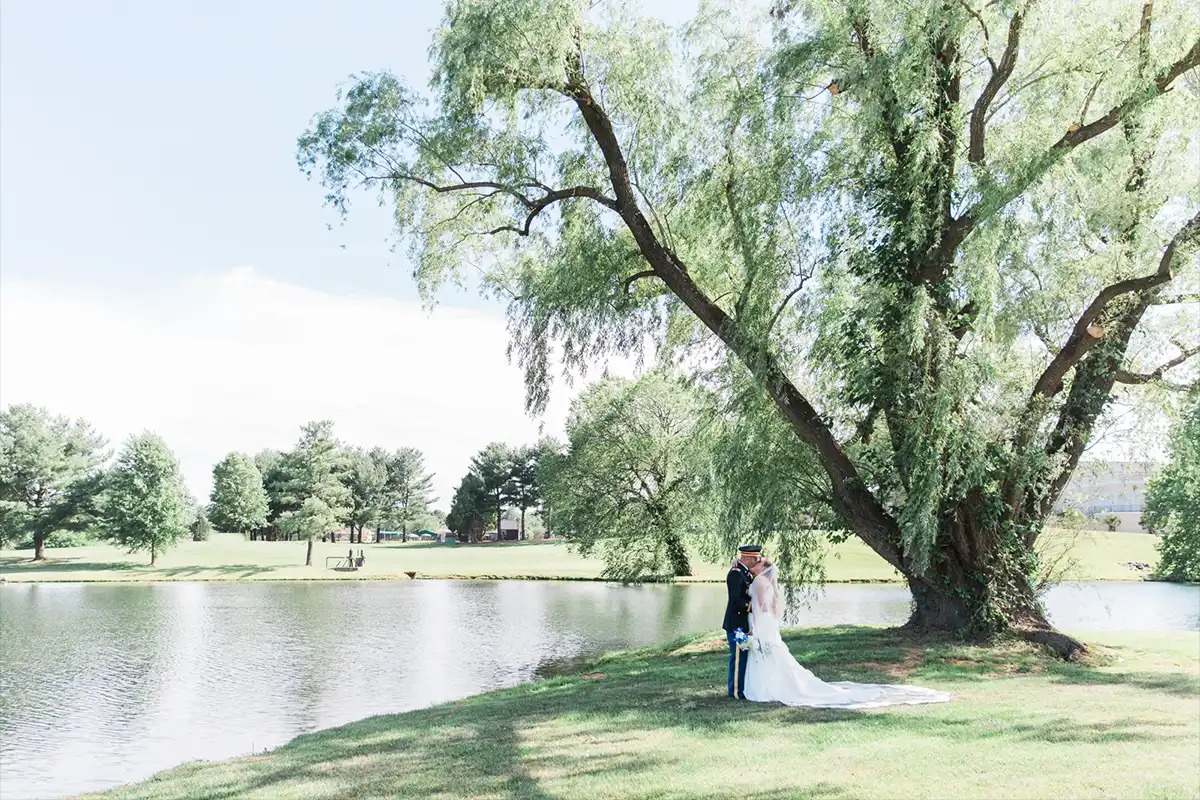 Bride and Groom kissing under large tree