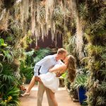 groom dipping his bride with spanish moss trees surrounding them