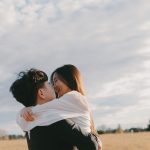 Couple holding each other in a field for engagement photo session