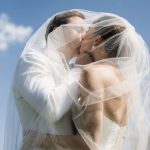 bride kissing groom under wedding veil