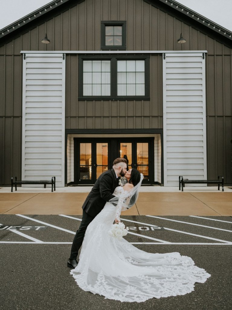 Bride and groom kissing in front of wedding reception space