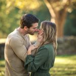 engagement photo with couple kissing in a park