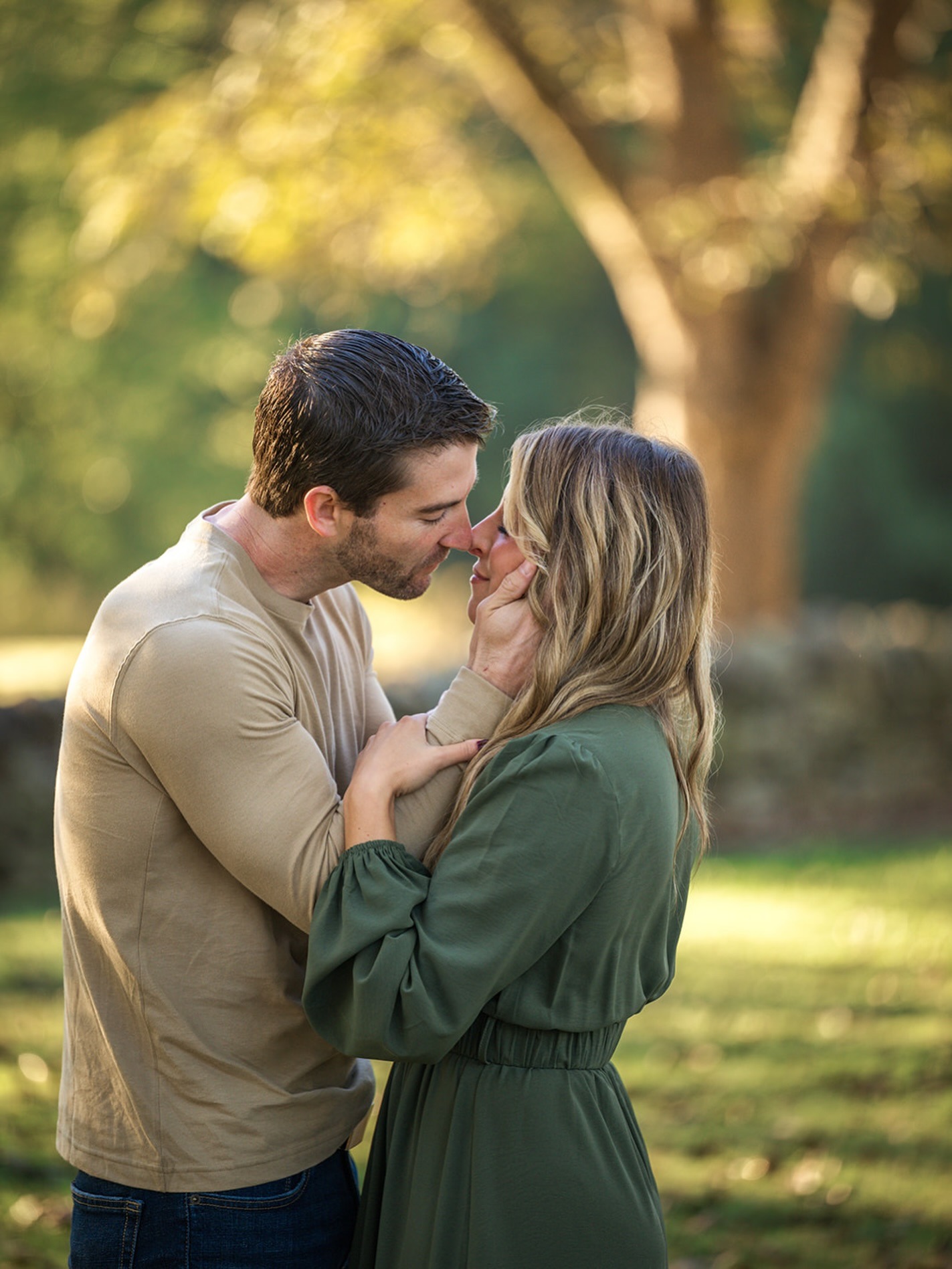 engagement photo with couple kissing in a park