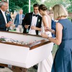 Bride and Groom with guests around a table with drinks