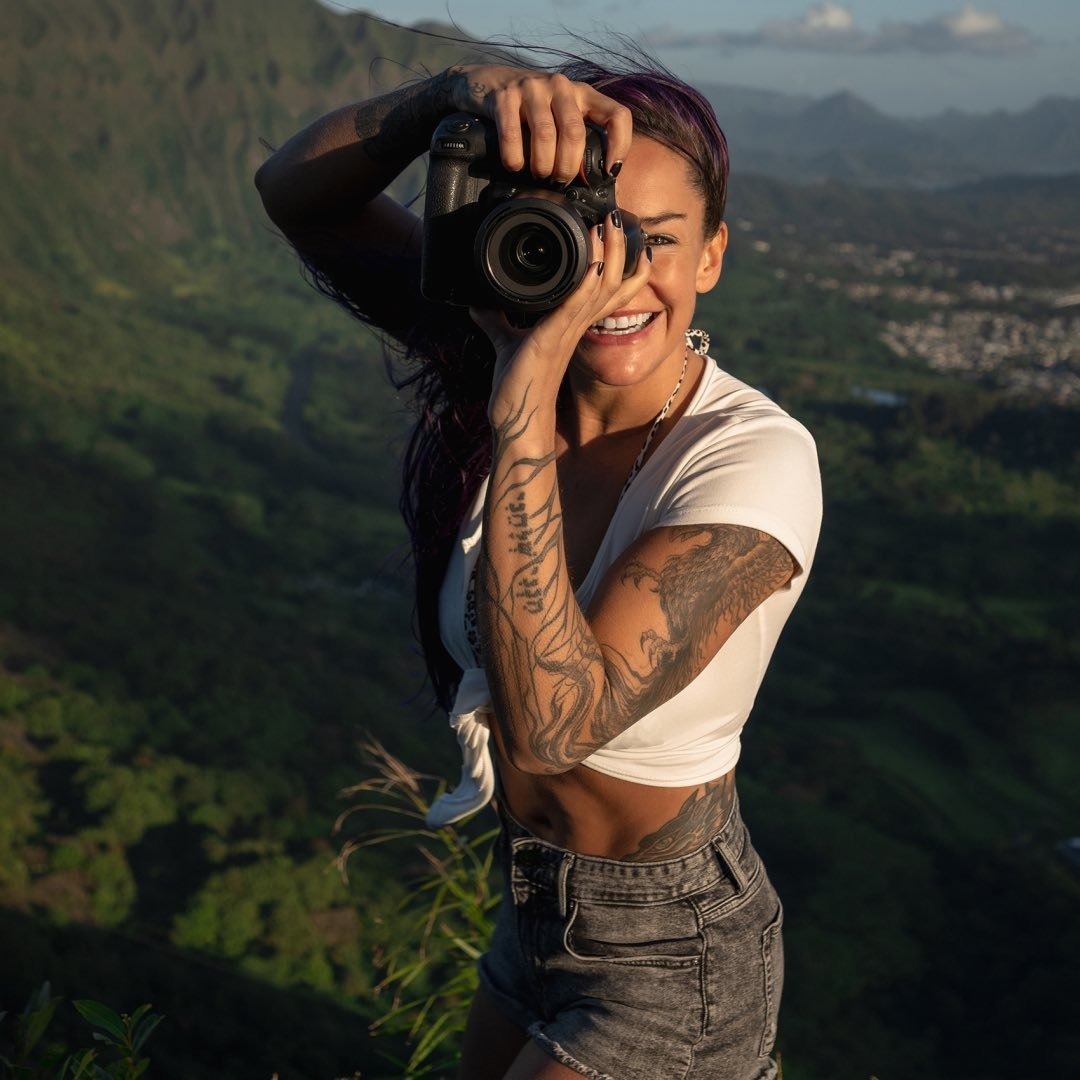Photo of photographer with a camera with a beautiful mountain view behind her