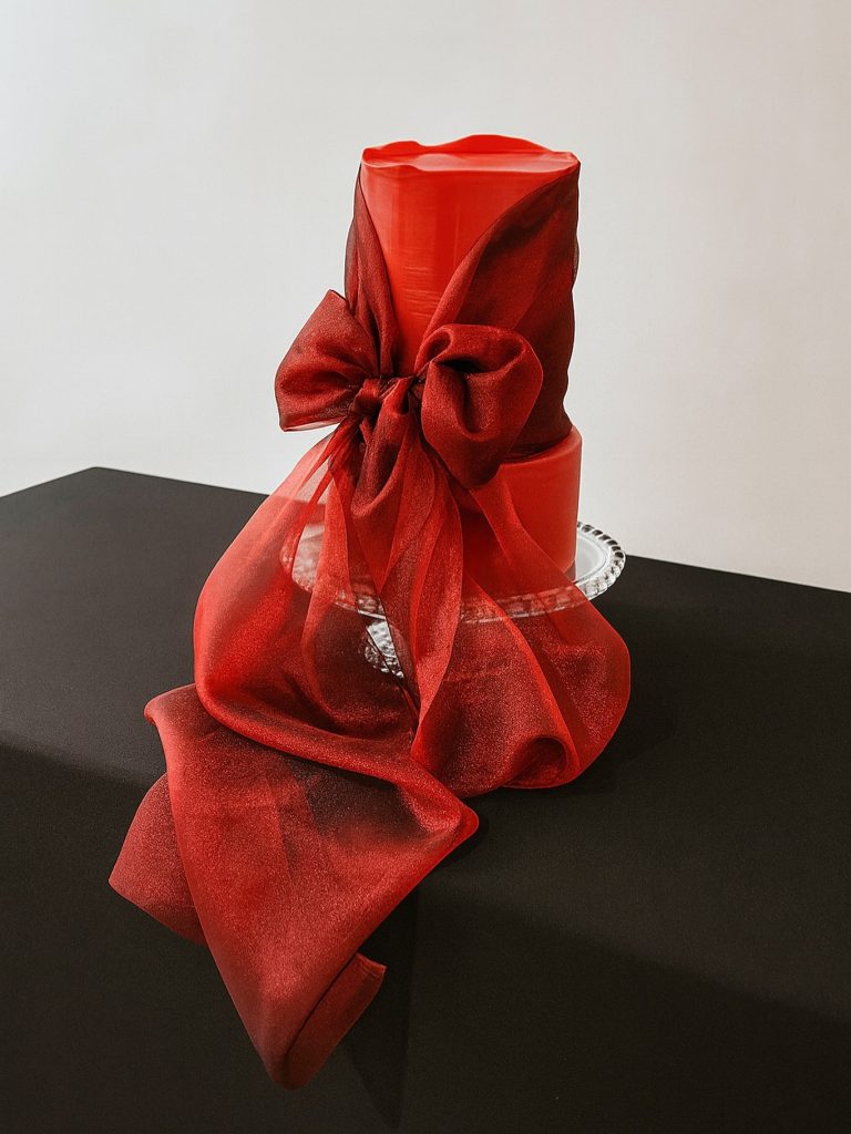 Red wedding cake with red sheer ribbon