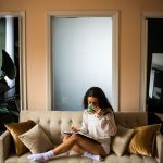 women sitting on couch with cozy socks and long sleeve on reading a book