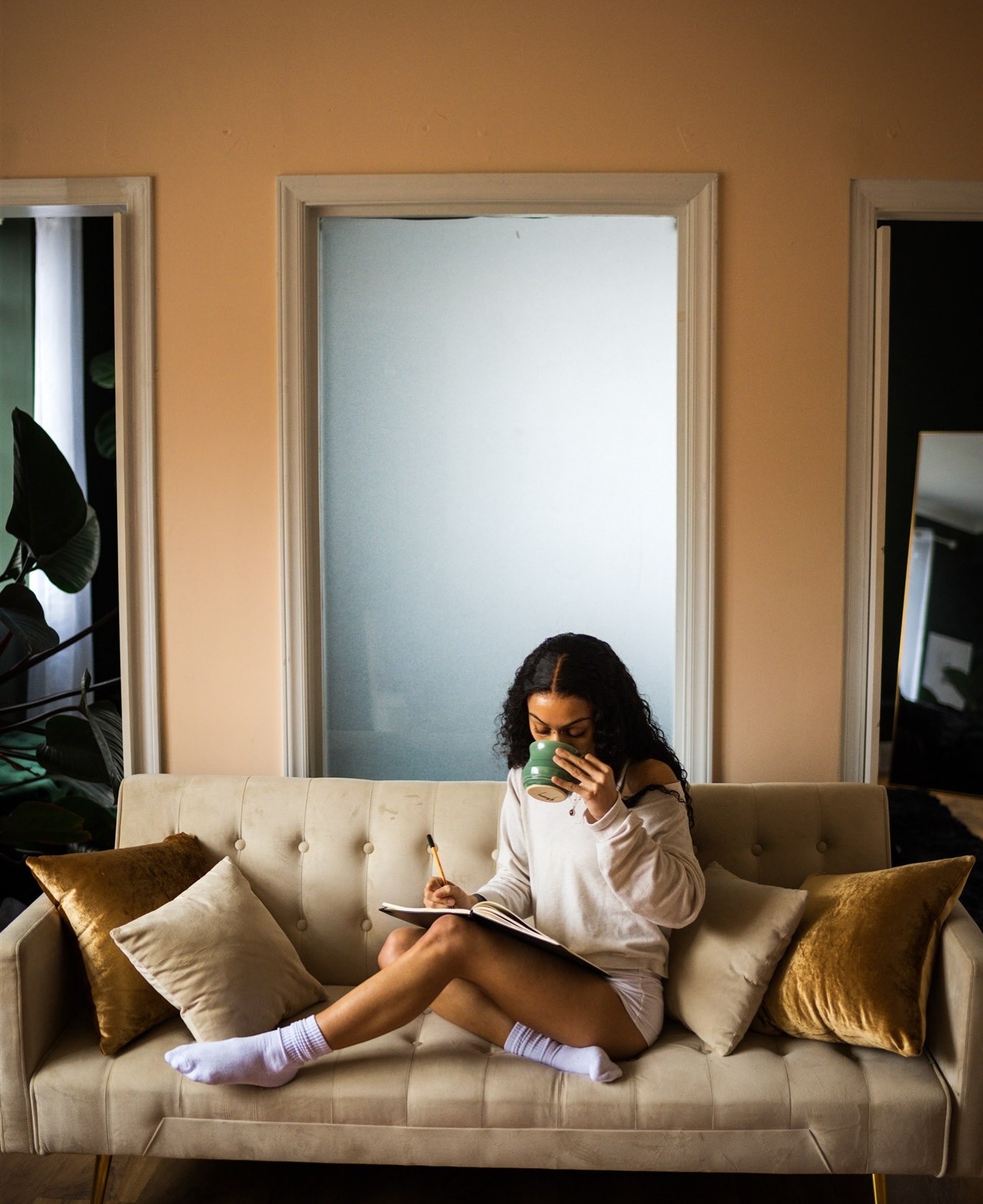 women sitting on couch with cozy socks and long sleeve on reading a book