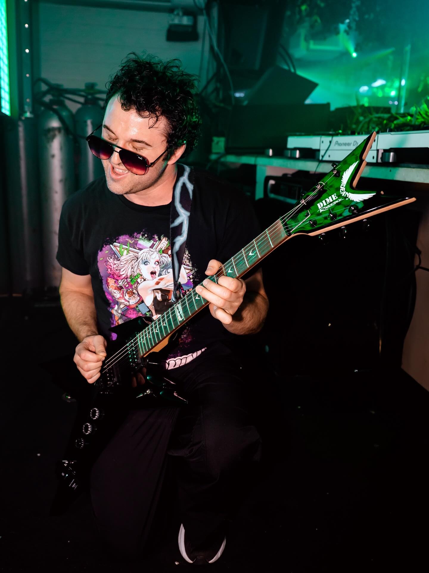 dj playing electric guitar in club