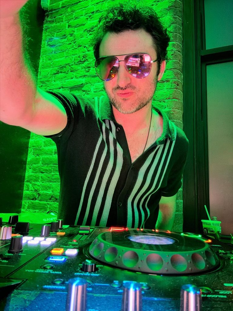 dj with dj spin board with sunglasses and green lighting