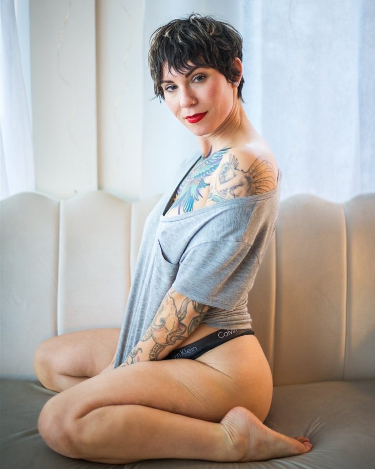 boudoir photo of a women with tattoos and baggy tshirt