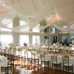 inside wedding reception space with soft white draping on the ceiling and simple elegant decor
