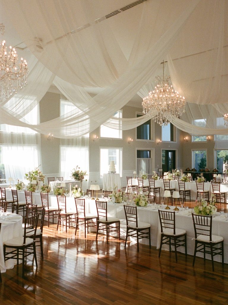 inside wedding reception space with soft white draping on the ceiling and simple elegant decor