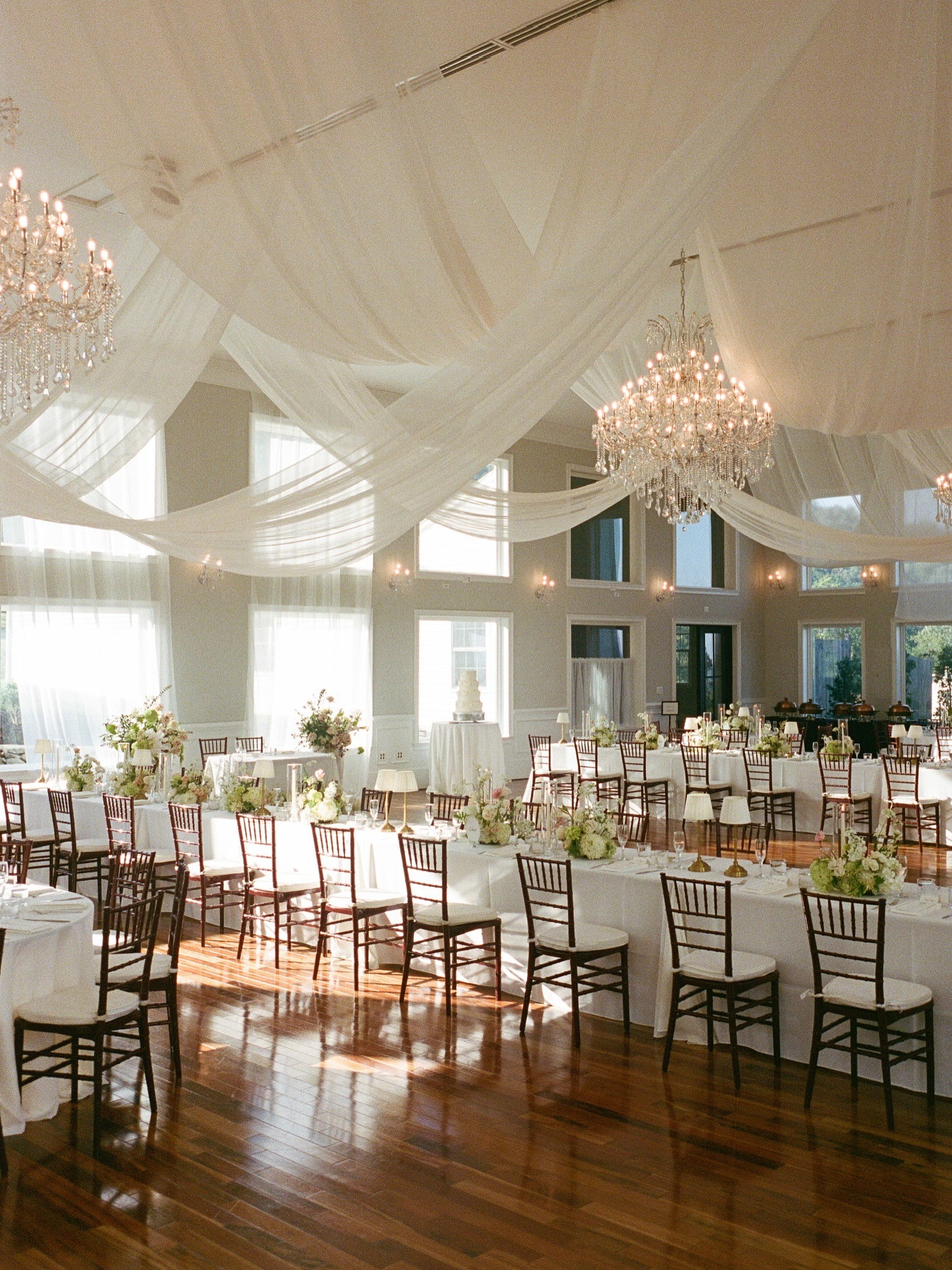inside wedding reception space with soft white draping on the ceiling and simple elegant decor