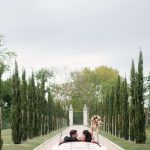 bride and groom in getaway car leaving venue surrounded by tall trees