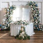 Sweetheart table surrounded by florals at indoor wedding