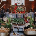 Appetizer table featuring birdcage with tomatoes