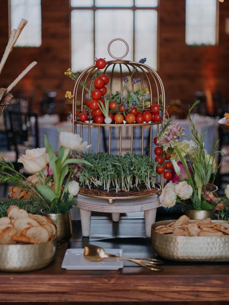Appetizer table featuring birdcage with tomatoes