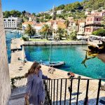 girl walking upstairs in craotia with beautiful water and sky views made possible with travel agent