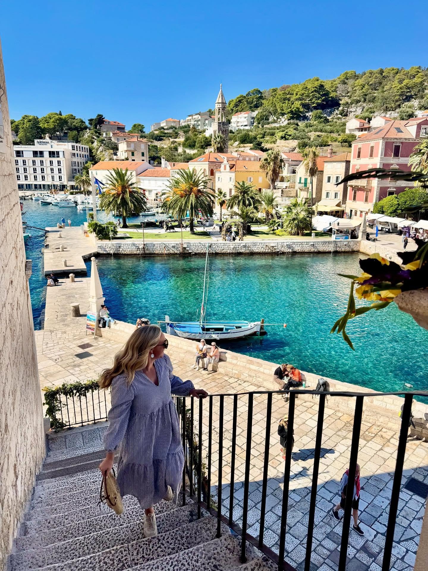 girl walking upstairs in craotia with beautiful water and sky views made possible with travel agent