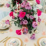 Close up of tablescape with gold chargers and purple and pink roses