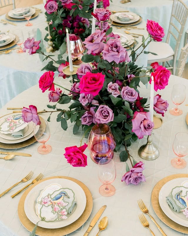 Close up of tablescape with gold chargers and purple and pink roses