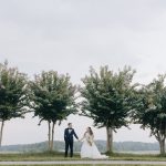 bride and groom taking outdoor wedding portraits near trees at golf course in northern virginia