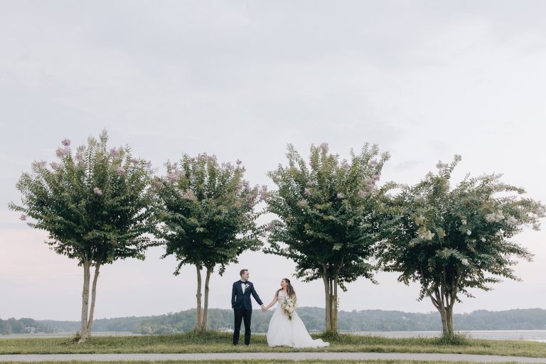 bride and groom taking outdoor wedding portraits near trees at golf course in northern virginia