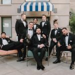 groom and groomsmen sitting and posing as a group before wedding ceremony