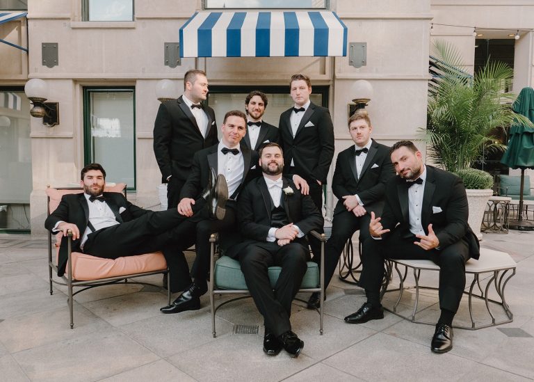 groom and groomsmen sitting and posing as a group before wedding ceremony