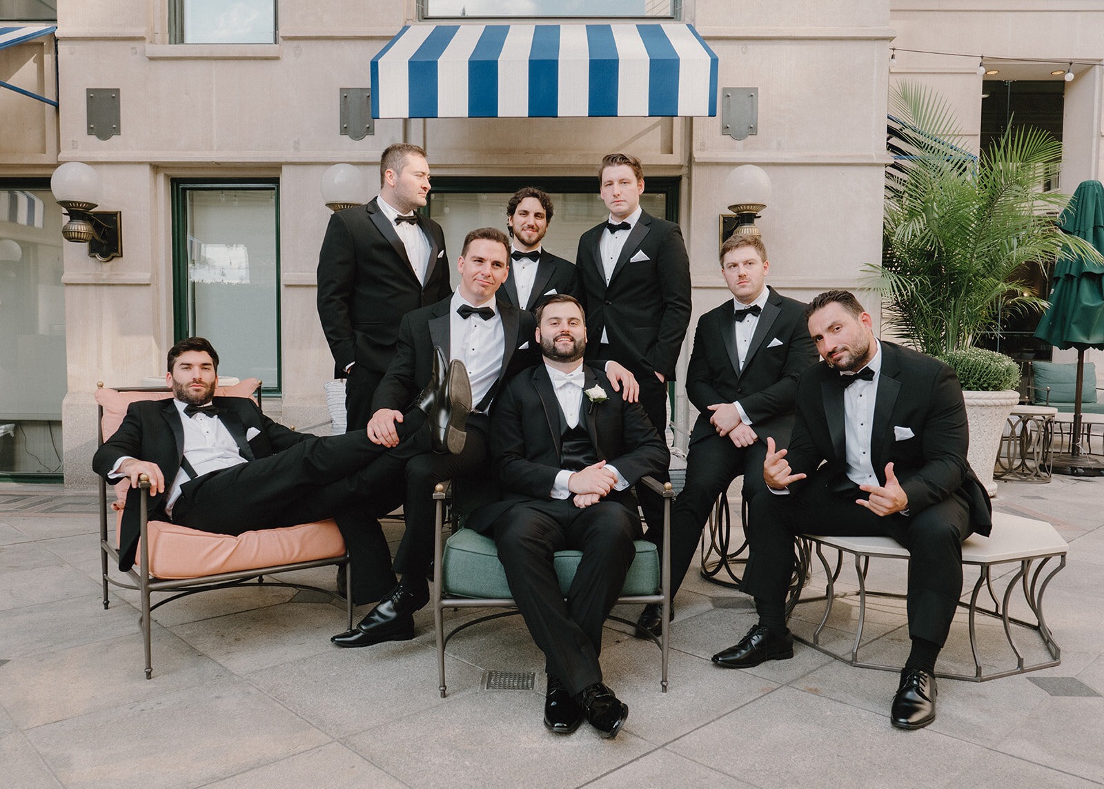 groom and groomsmen sitting and posing as a group before wedding ceremony