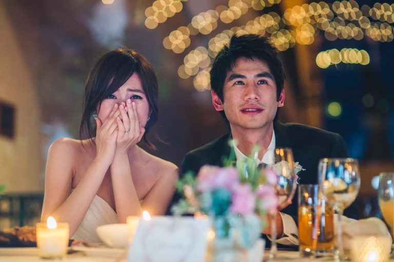 Couple listening to wedding speeches during reception
