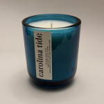 "Carolina Tide" candle in a deep cerulean blue glass jar with a white vertical label and scent profile.