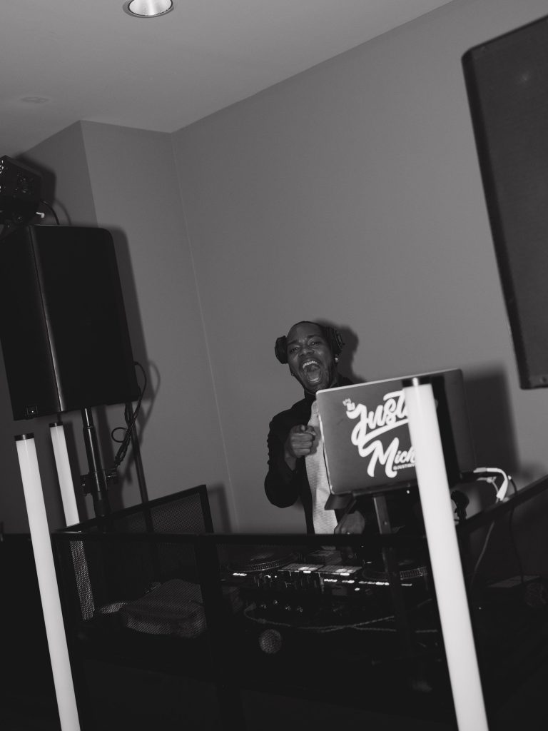 Spin Society DJs booth and DJ spinning music for a wedding reception.