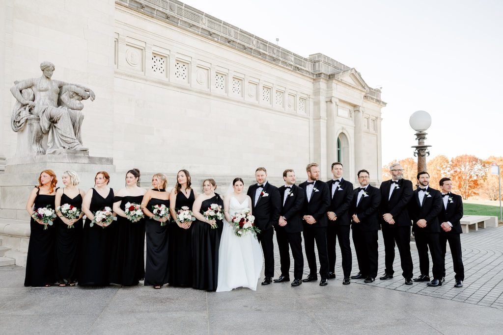 Bride and groom posing with their wedding party in front of the St. Louis Art Museum. Photographed by Danielle Ambry Photography.
