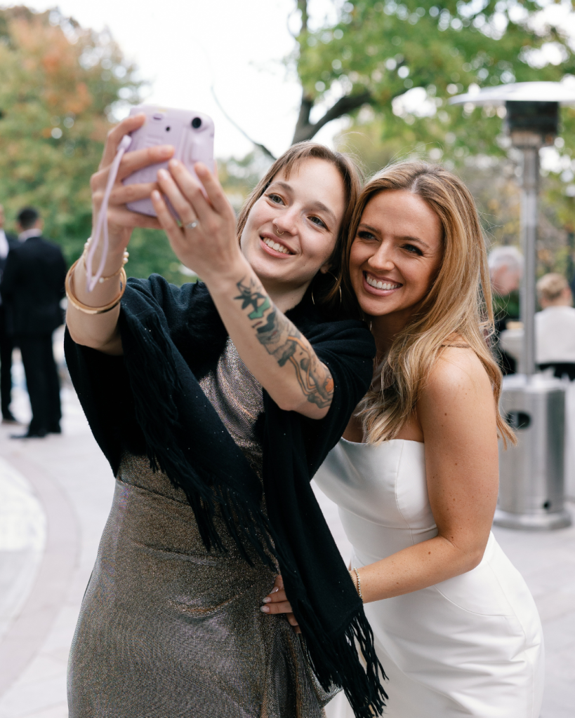 bride and guest taking selfie at cocktail hour