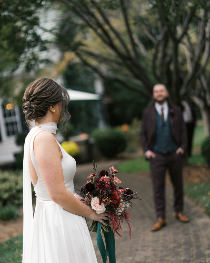 Bride holding a rich burgundy and blush bouquet during an emotional first look at The Morehead Inn in Charlotte, North Carolina.