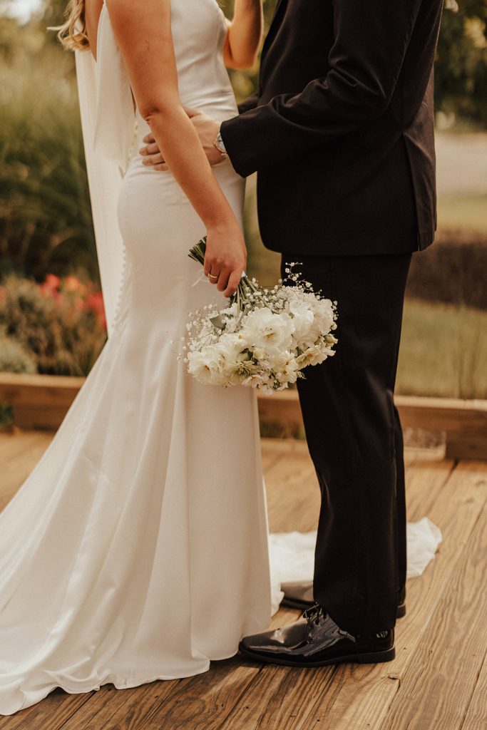 Close-up of bride and groom holding bouquet during outdoor wedding portraits at Delaware golf course venue