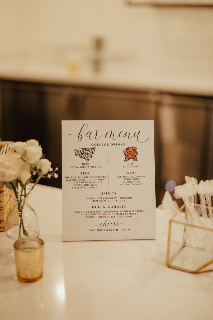 Custom wedding bar menu with college-themed cocktails displayed at Bayside Resort Golf Club reception