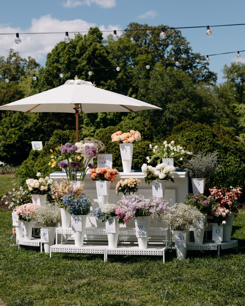 flower bar guest seating chart at outdoor countryside wedding venue