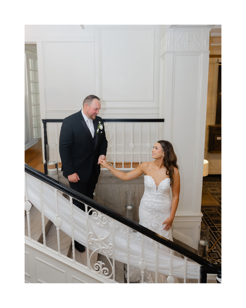 Bride and groom sharing a romantic staircase portrait inside The Hotel Concord wedding venue in Concord NC.